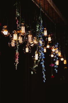 a chandelier filled with lots of lights and flowers hanging from it's ceiling