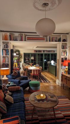 a living room filled with lots of furniture and bookshelves on top of it