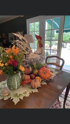 a wooden table topped with pumpkins and flowers