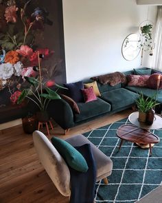 a living room filled with furniture and a large painting on the wall above it's windows