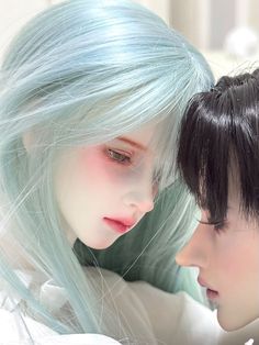 two dolls are looking at each other with blue hair