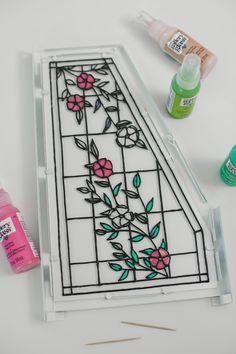 some crafting supplies are laying out on a white surface with flowers and leaves painted on them