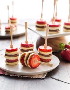 strawberries are arranged on small appetizers with toothpicks