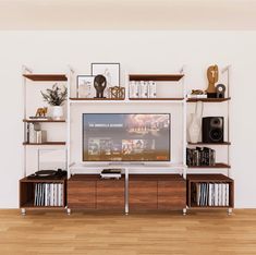 there is a television on the entertainment center in this living room with bookshelves