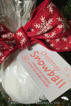 a christmas ornament hanging on a tree with a red and white ribbon tied around it