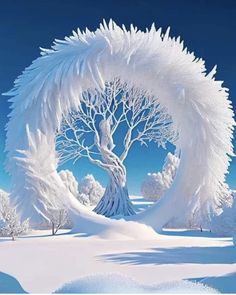 a large white tree in the middle of a snow covered field with blue sky and clouds