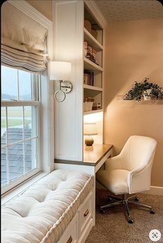 a white chair sitting in front of a window next to a desk and bookshelf