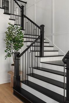 Modern farmhouse entryway design with matte black wooden staircase in McKinney, Texas. Stairs Modern Farmhouse, Farmhouse Foyer Staircase, Light Wood Floors With Black Accents, Stairs White And Black, Black And White Wooden Staircase, Black And Wood Staircase Modern, White Stairs Black Metal Railing, Modern Painted Stairs, Black Wooden Handrails For Stairs