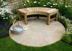 a wooden bench sitting on top of a lush green field next to a flower garden