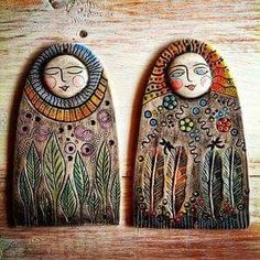 two wooden wall hangings with faces painted on them