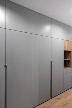 an empty room with some gray cabinets and wood flooring