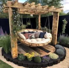 a wooden swing bed in the middle of a garden