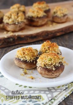 stuffed mushrooms on a white plate with crumbs