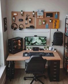 a desk with a computer on it in front of a wall mounted monitor and speakers