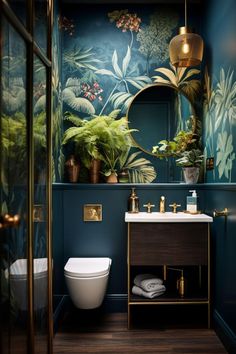 a bathroom with blue walls and green plants on the wall, gold fixtures and a white toilet