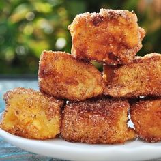 a white plate topped with fried food on top of a blue table covered in powdered sugar