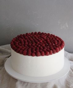 a white cake with raspberries on top