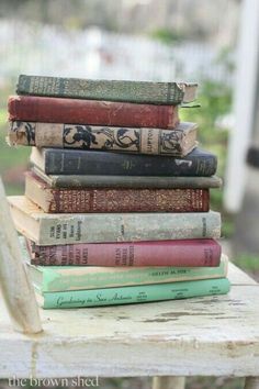 a stack of books sitting on top of a wooden table