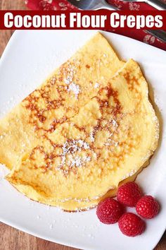 a plate topped with crepes covered in powdered sugar and raspberries