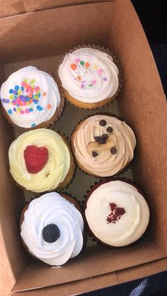 a box filled with different types of cupcakes