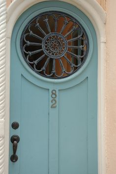 a blue front door with an ornate glass window