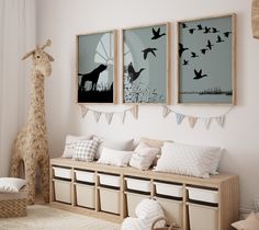 a living room with two giraffes hanging on the wall and some pillows