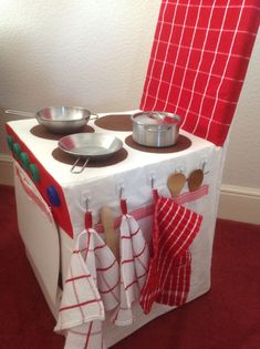 an oven with pots and pans on top of it next to a red chair