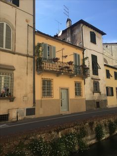 an old building with balconies on the windows and balconys next to a canal