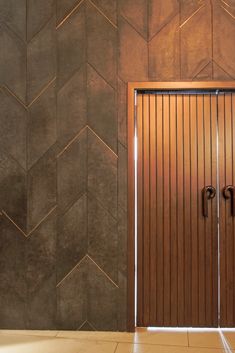 a wooden door in front of a tiled wall