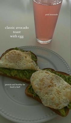 an egg and avocado toast with egg on a plate next to a drink