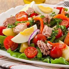 a white plate topped with salad and hard boiled eggs