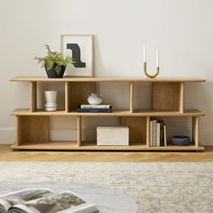 a living room with a book shelf and vases on top of the bookshelves