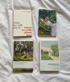 three books laying on top of a white bed next to each other in front of a white sheet