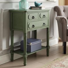 a green table with two drawers and a blue bird on it next to a chair