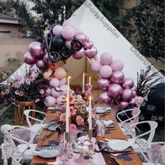 a table set up with balloons and candles