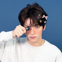 a young man holding a hair dryer to his forehead