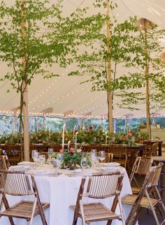 the tables are set with white linens and greenery for an elegant wedding reception