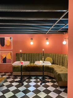 a checkered floor in a room with two couches and candles on the tables