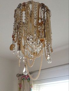 a chandelier hanging from the ceiling in a room with white walls and curtains