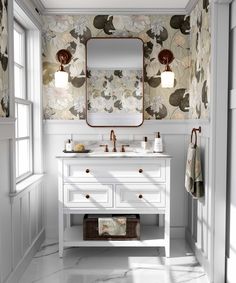 a bathroom with floral wallpaper and white vanity, blue rug and gold framed mirror