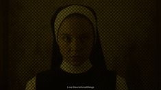 a woman with a nun's head in front of a screen shot from the movie