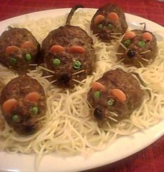 some meatballs with carrots and green peas on top of noodles in a white plate