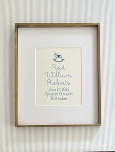 a baby's birth announcement is framed in a gold frame with a white background