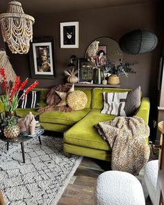 a living room filled with green couches and pictures on the wall above them,