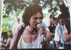 a man holding a microphone in front of a group of people