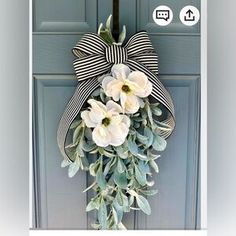 a door with a bow and flowers hanging on it's side, in front of a blue door