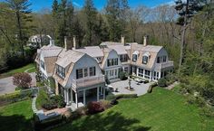 an aerial view of a large house in the middle of a wooded area with lots of trees