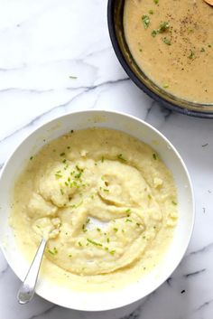 two bowls filled with mashed potatoes and garnished with parsley