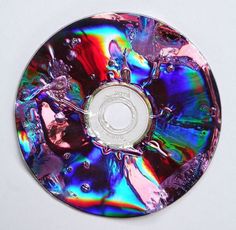 a cd that is sitting on top of a white surface with water droplets all over it