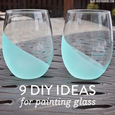 two wine glasses sitting on top of a table next to each other with blue liquid in them